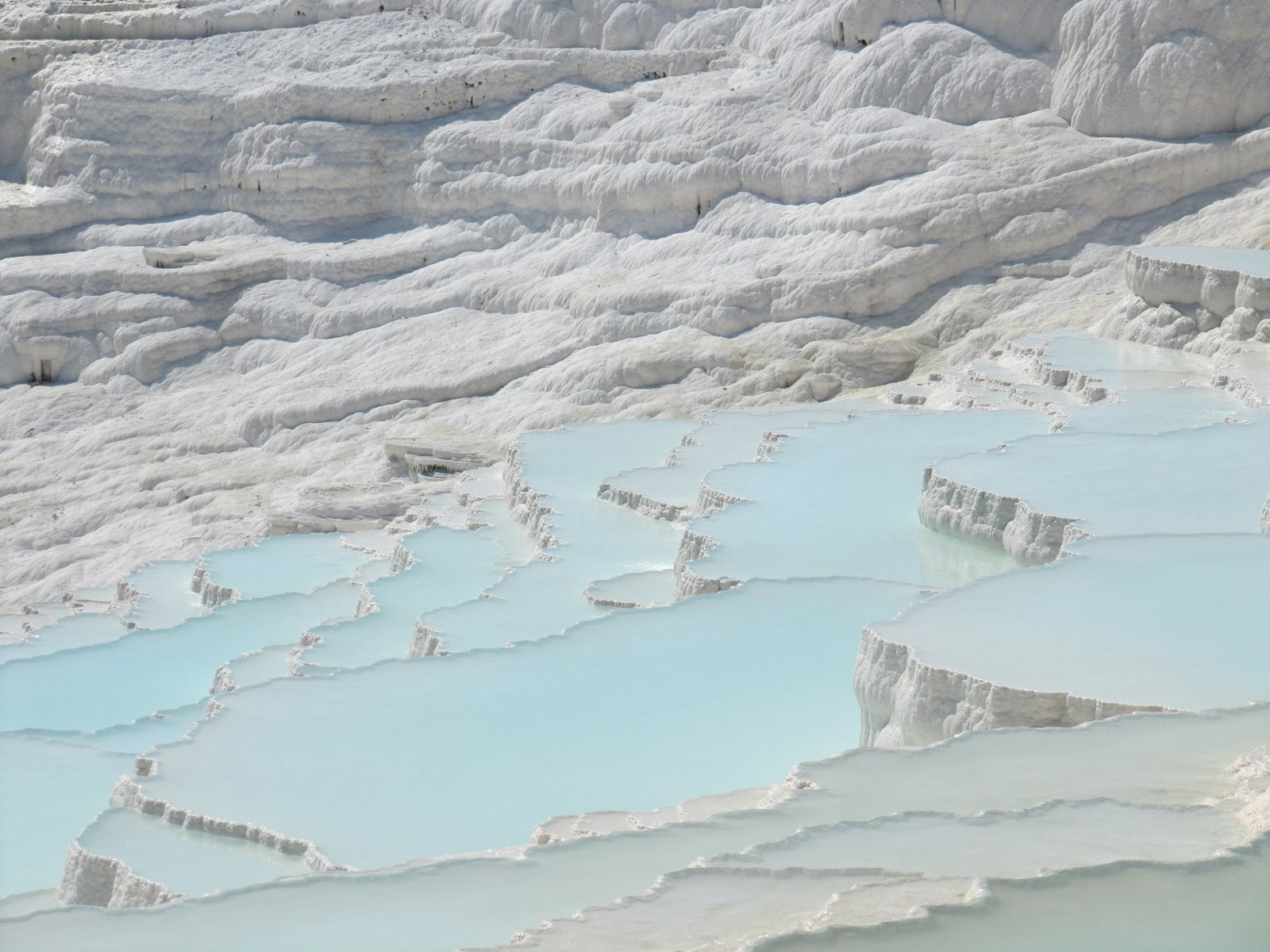 Pamukkale travertine terraces filled with pale blue thermal water